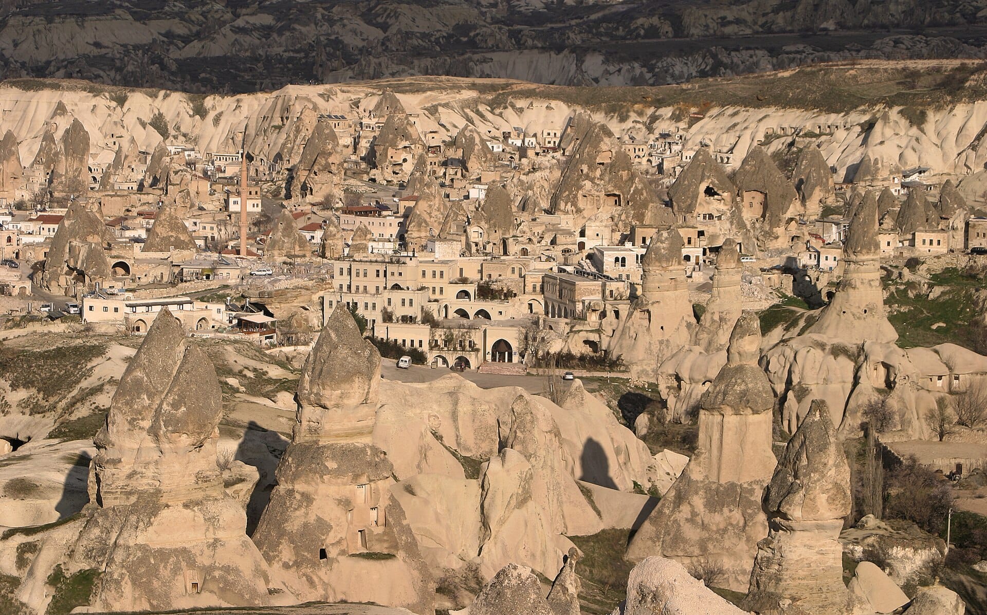 Pale cones and ridges of volcanic tuff in the Göreme valley under a wide sky